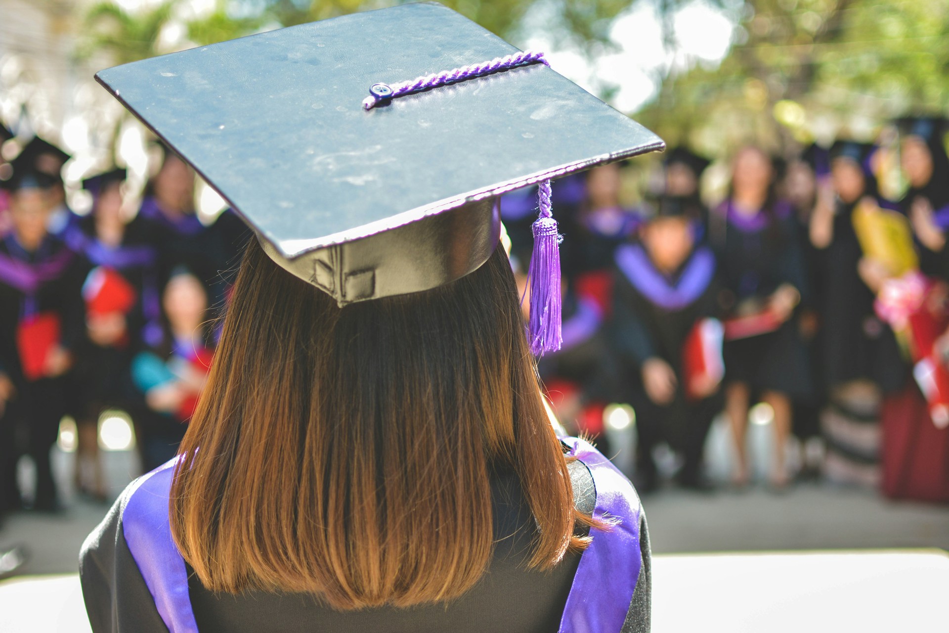 College graduate holding diploma and cap, symbolizing achievement and the payoff of educational planning.